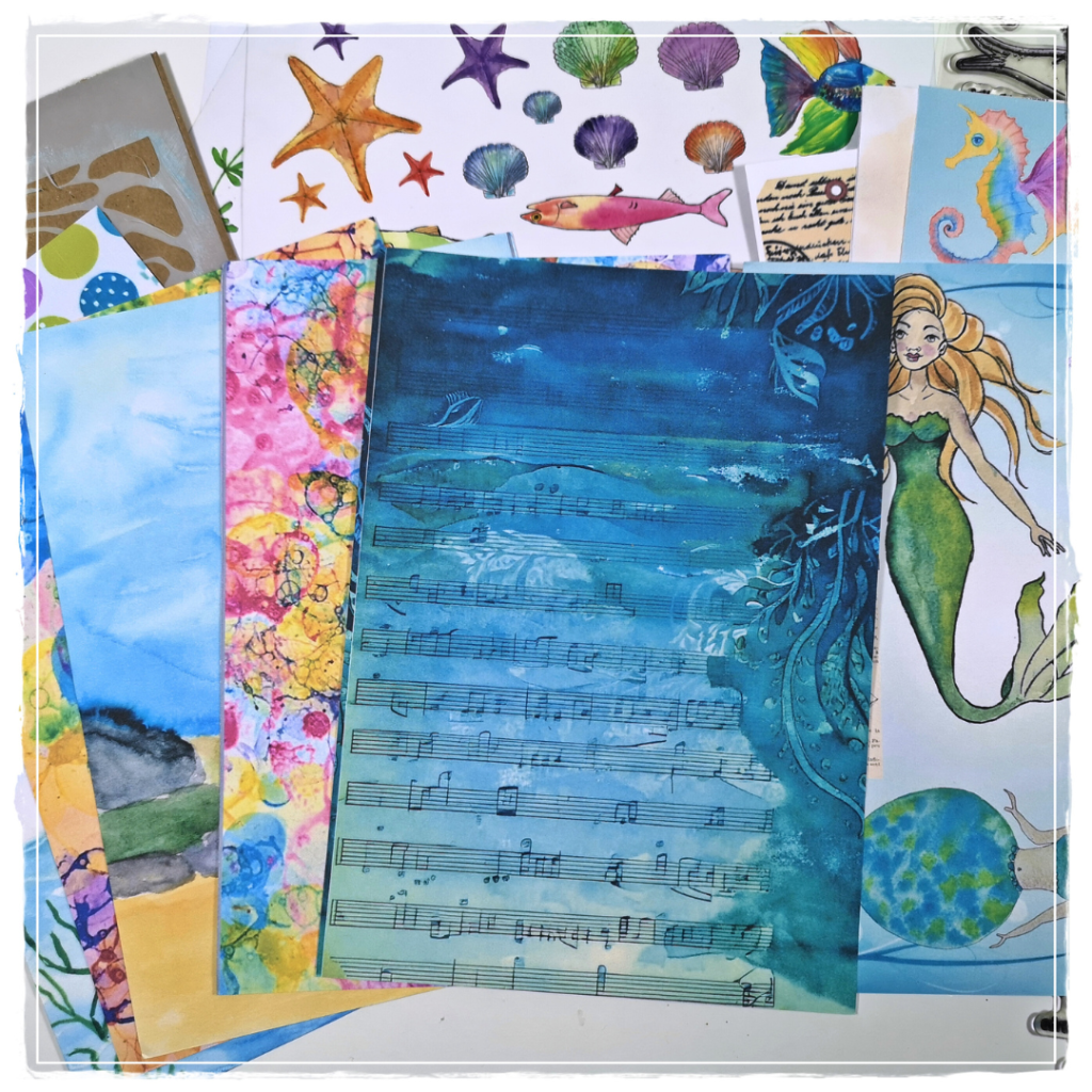 Summer mini album using Mermaid Fairies collage paper and Ocean Treasures washi stickers from Bea Grob's collection, surrounded by cut-out mermaids and sea creatures