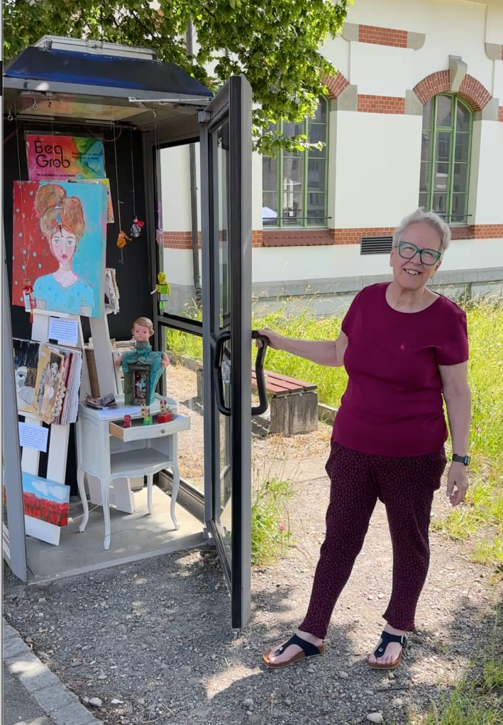 Bea Grob in front of her mini phone booth exhibition