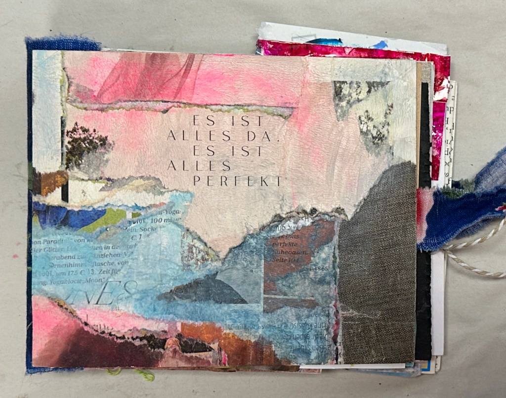 A mixed media art journal page featuring abstract imagery and text in German that reads 'Es ist alles da. Es ist alles perfekt.'