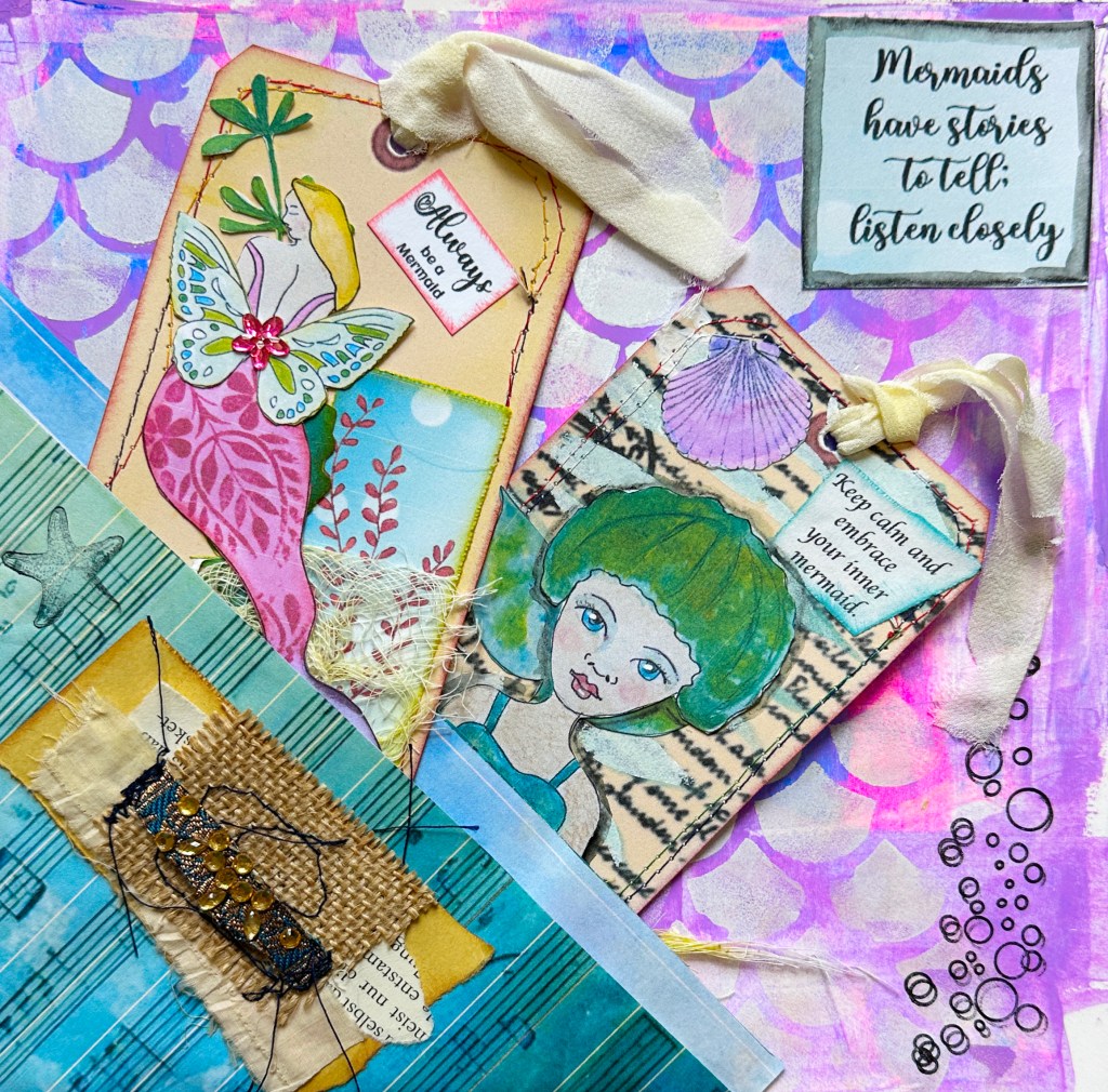 A colorful mixed media art journal page featuring a dreamy mermaid pocket, two handmade tags, and a stitched collage cluster, with a whimsical underwater theme and inspirational phrases.