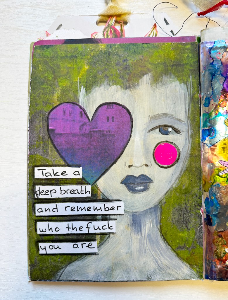 Art journal page featuring a painted face with a heart shape over one eye and a pink circle on the cheek, accompanied by bold text that reads 'Take a deep breath and remember who the fuck you are.'