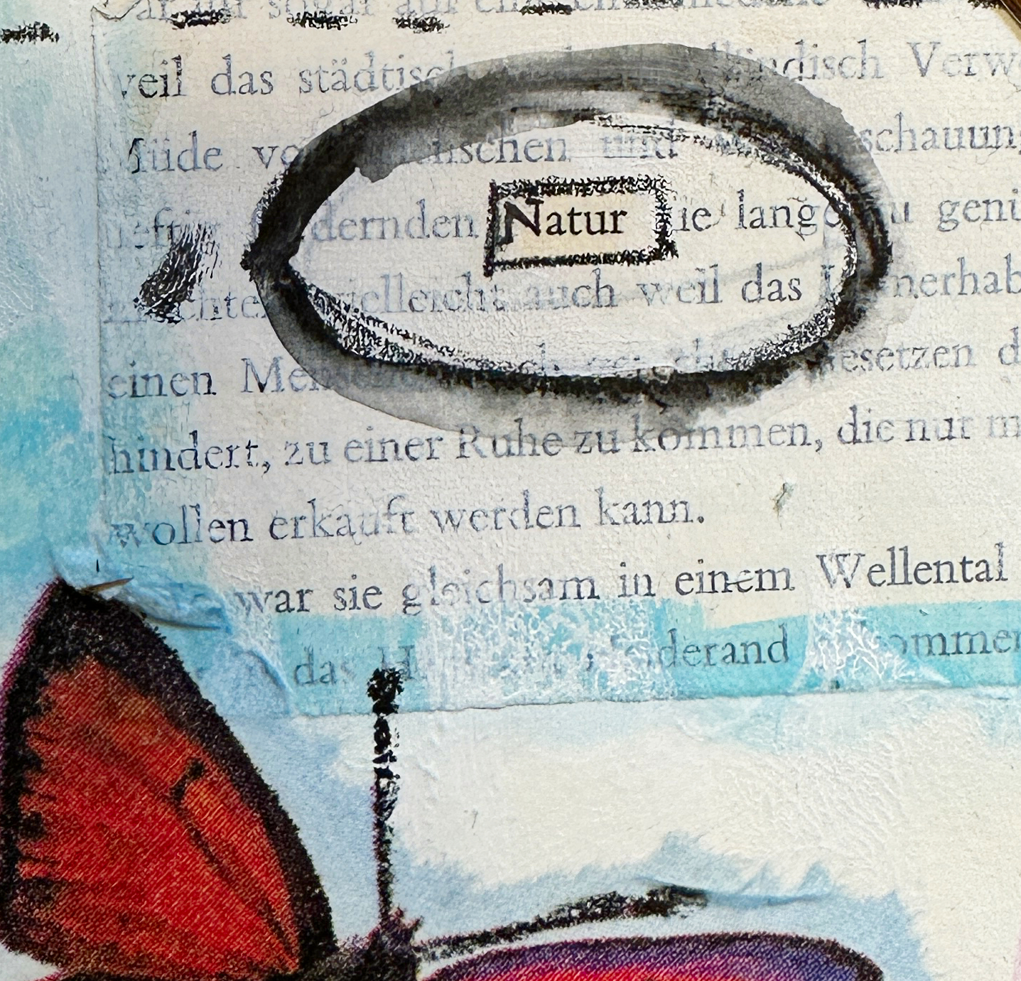 Close-up of a mixed media art journal page with the word “Natur” circled and a red butterfly wing.