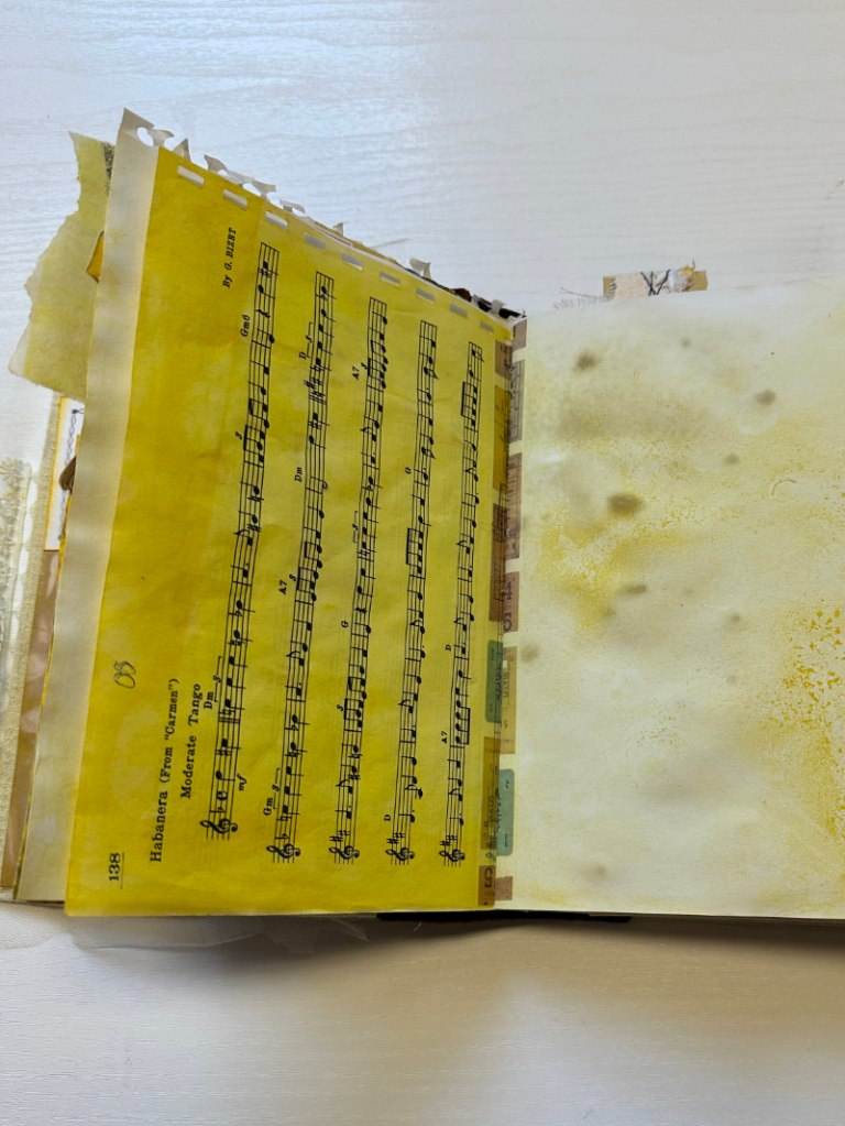 Turmeric-dyed music-sheet page from Bea Grob’s Golden Thread Art Journal workshop, showing aged texture and warm yellow tones.