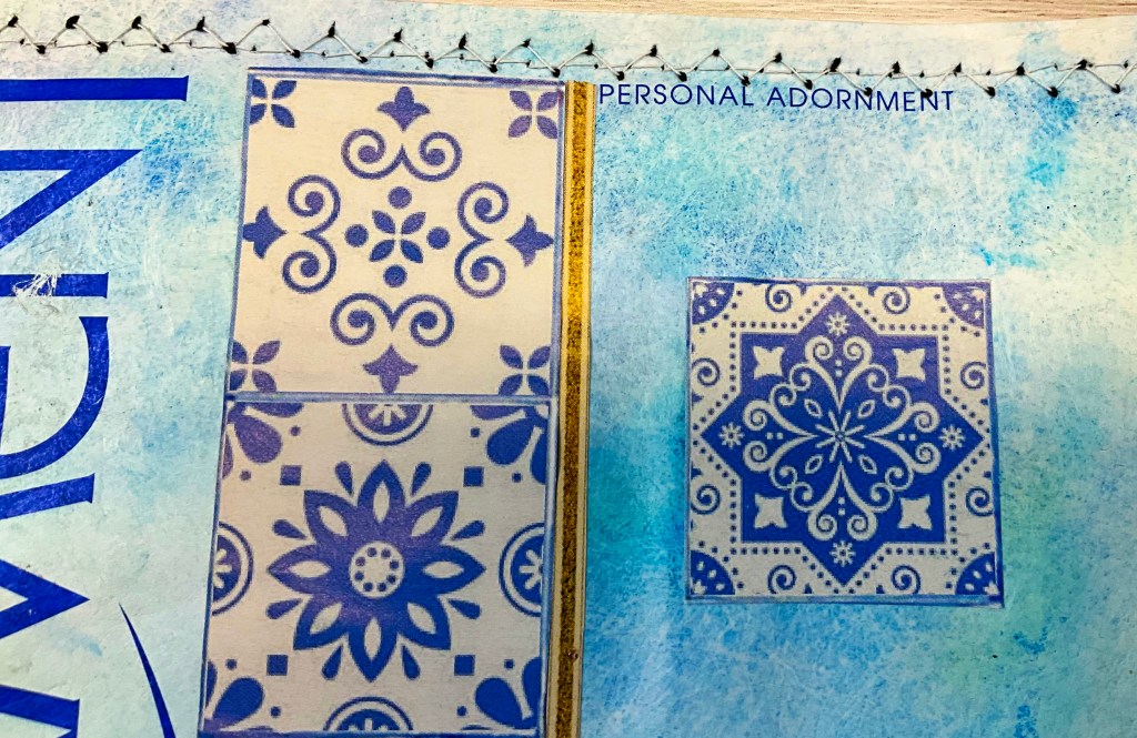 Close-up of decorative blue patterns on a page from a repurposed fashion catalog, featuring intricate designs and textures.