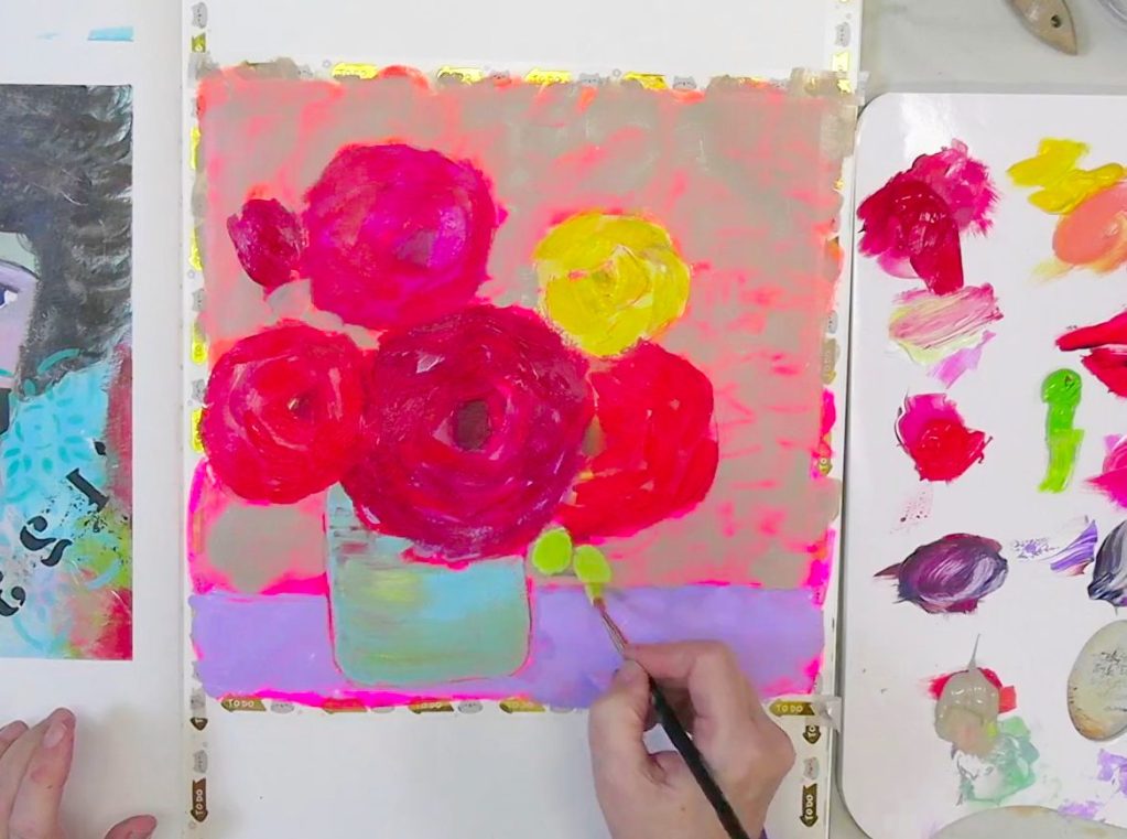 A vibrant mixed media flower bouquet in progress, with bold fluorescent pink and orange background, and rich red and yellow blooms being painted in an A3 Moleskine Art Journal.