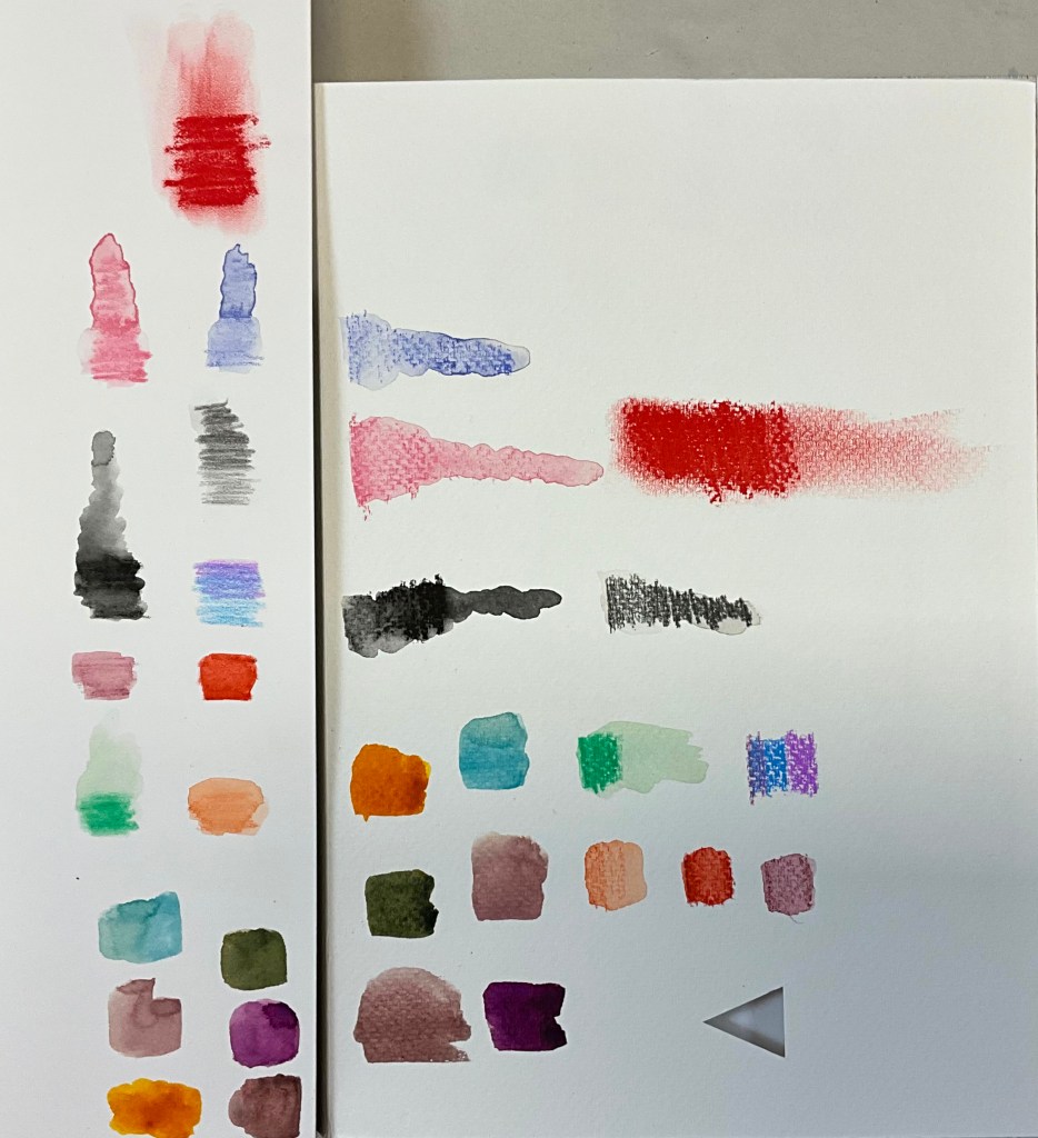 Swatches of various acrylic and watercolor paints on paper, showcasing different colors and textures.