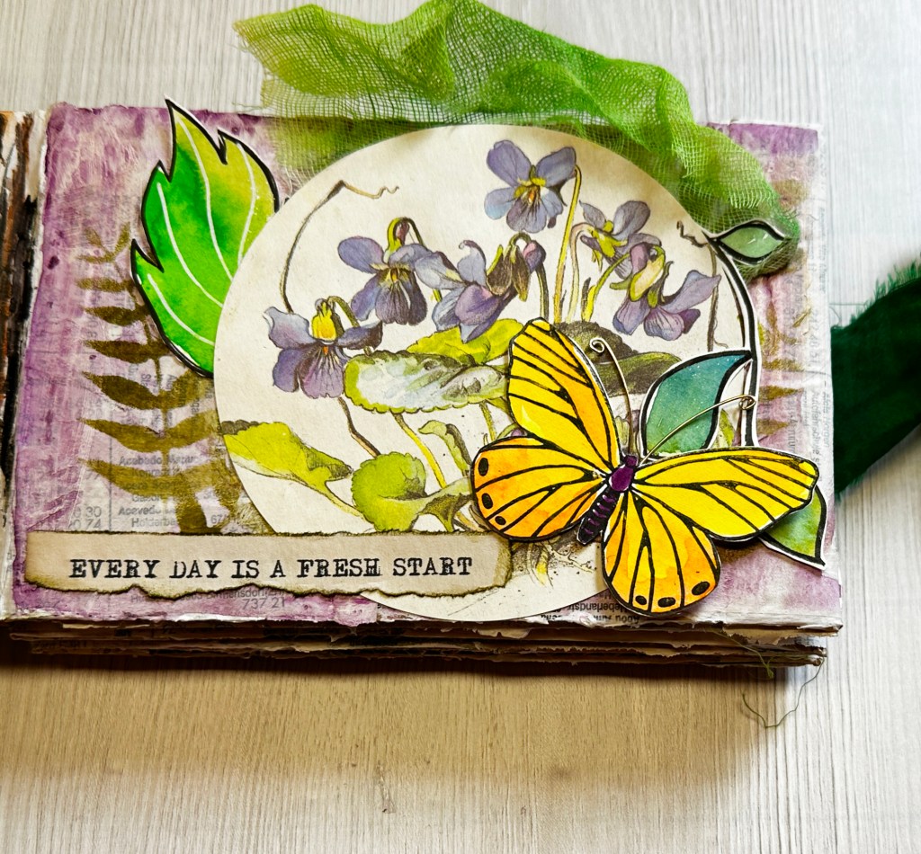 A decorated page featuring a butterfly and flowers, with the phrase 'Every day is a fresh start' prominently displayed.