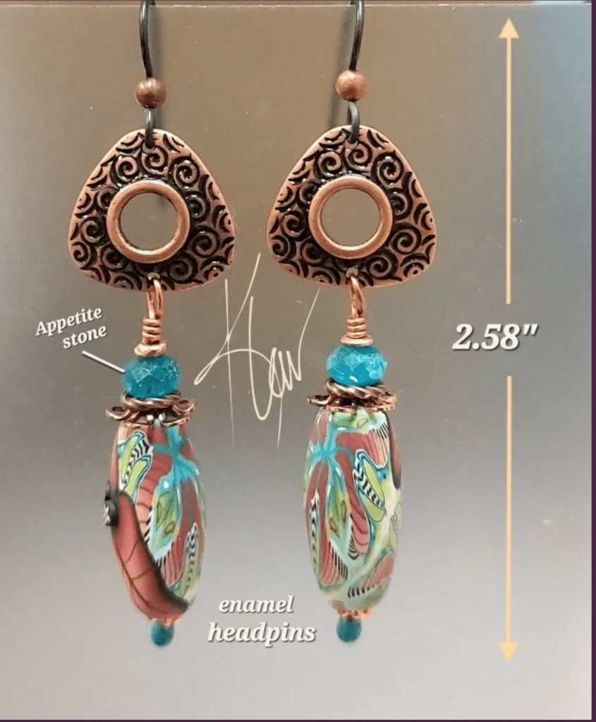 A pair of handcrafted earrings featuring intricate enamel headpins, appetite stones, and vibrant colors. The earrings are 2.58 inches in length.