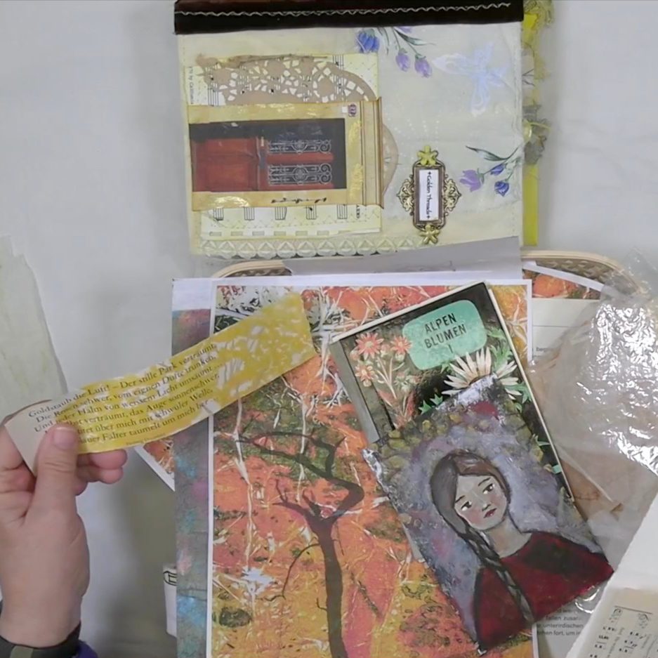 An assortment of art supplies and papers, including a colorful collage with a painted girl and a yellow text strip, displayed on a light surface.