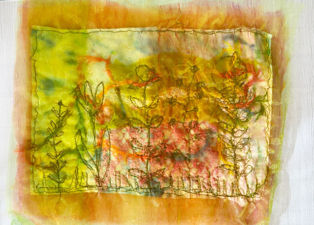 First free-motion embroidery experiment by Bea Grob, hand-stitched botanical motifs on organza fabric in yellow, orange and pink tones